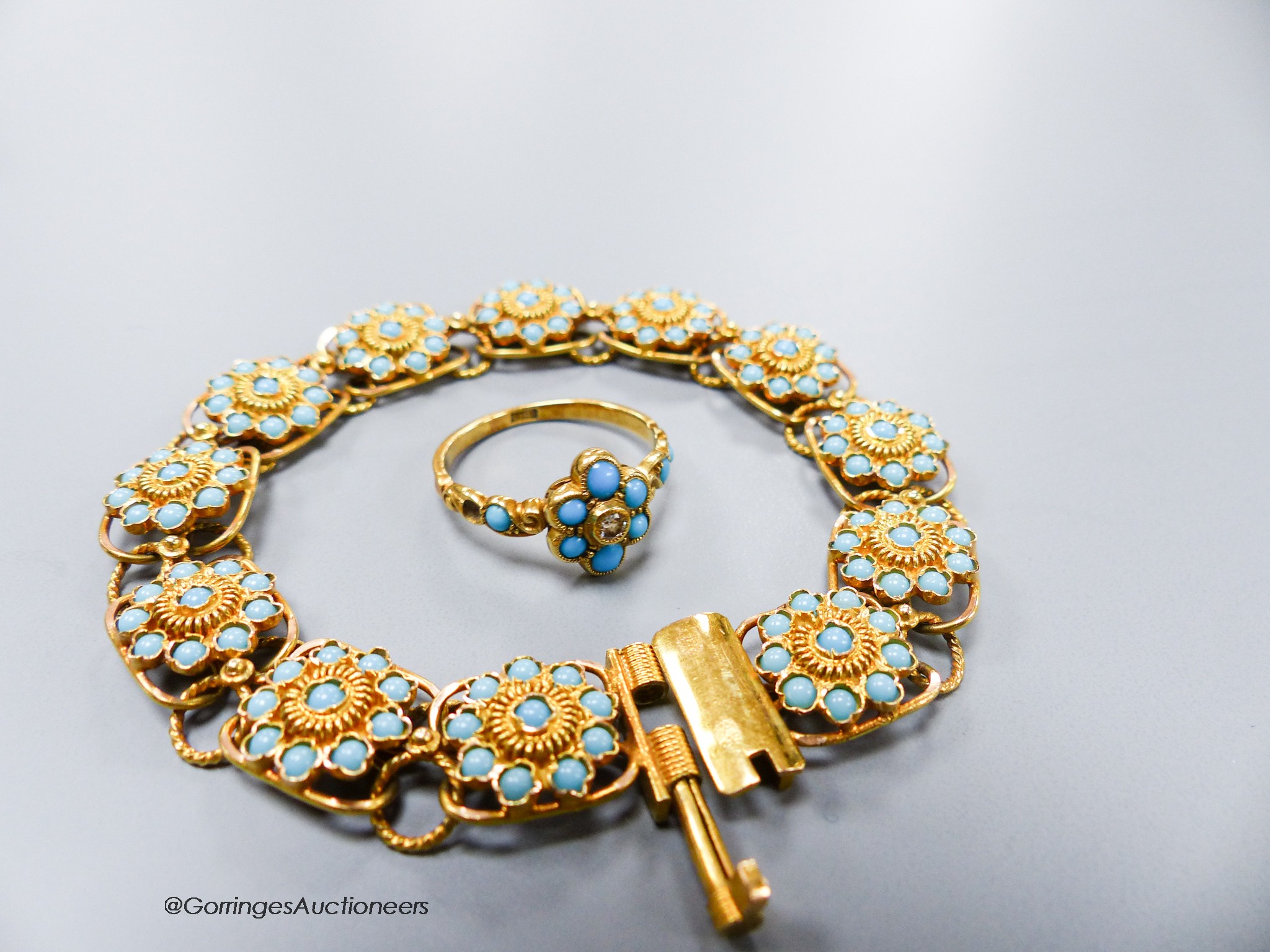 A yellow metal and blue enamel flower form twelve-cluster bracelet, 16.5cm, gross16.1 grams and an 18ct, turquoise and diamond ring, size M, gross 2.7 grams.